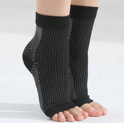 Hälsporrestrumpor med kompression i svart som ger stöd runt häl och fotvalv, burna på båda fötterna.