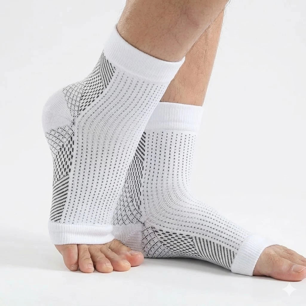 Hälsporrestrumpor med kompression i vitt som ger stöd runt häl och fotvalv, burna på fötterna.