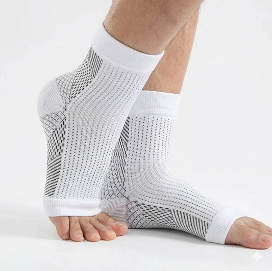 Hälsporrestrumpor med kompression i vitt som ger stöd runt häl och fotvalv, burna på fötterna.